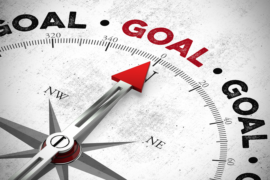 Compass points to the word goal / goal with a red compass needle