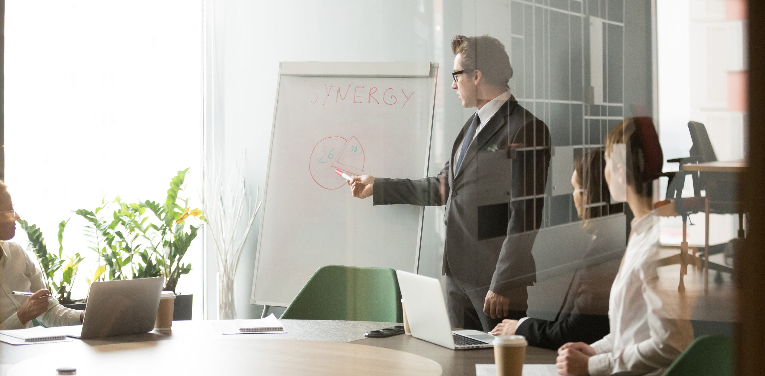 Serious Businessman Talking Giving Presentation On Flipchart, Ex Serious Businessman Talking Giving Presentation On Flipchart